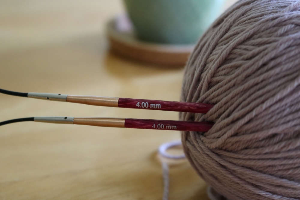 A ball of yarn with circular knitting needles sticking in it