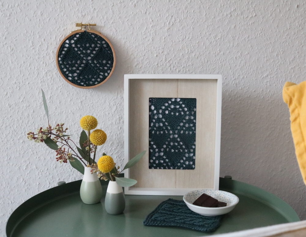 Decoration with gauge swatches in picture and embroidery frames and as crochet doily under plate with chocolate