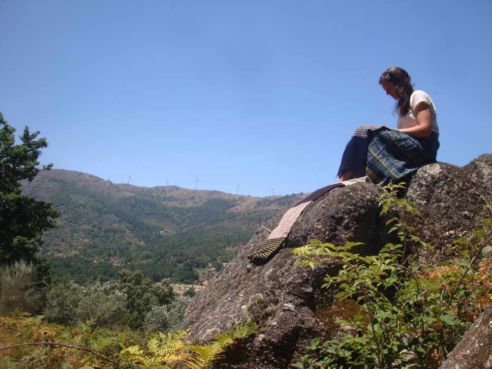 knitting woman sitting outside in the hills